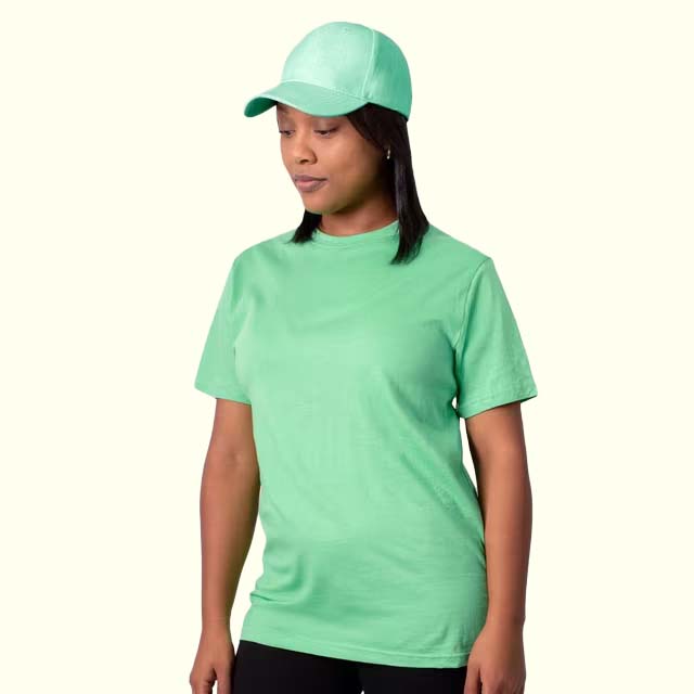 Person wearing a light green t-shirt and cap on a white background